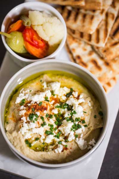 Overhead view of hummus, pita and vegetables